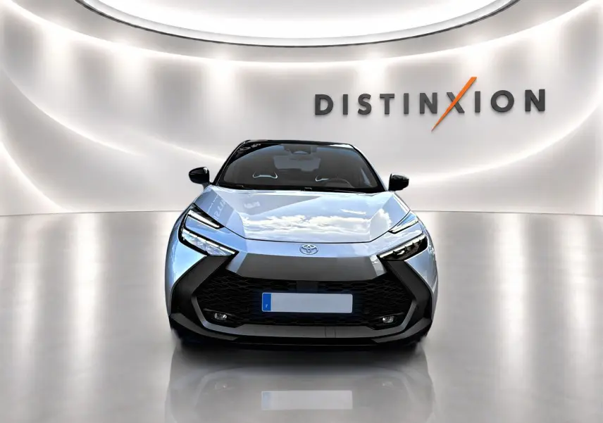 Vue avant d'un Toyota C-HR gris 2025 avec calandre noire et phares LED, dans un showroom lumineux "Distinxion".