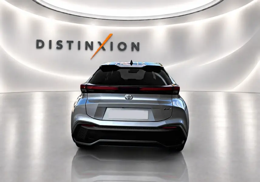 Vue arrière d'un Toyota C-HR 1.8 hybride gris 2025 dans un showroom avec logo Distinxion en arrière-plan.