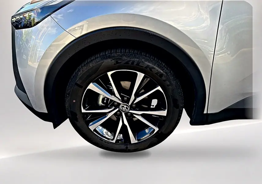 Gros plan sur la roue avant gauche du Toyota C-HR 1.8 hybride gris avec jante alliage noir et argent.