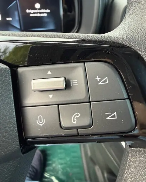 Gros plan sur les commandes au volant du Citroën Berlingo blanc 2026, avec boutons de volume et téléphone intégrés.