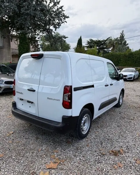 Vue 3/4 arrière droite d’un Citroën Berlingo blanc 2026 version utilitaire avec portes arrière pleines et protections latérales noires.