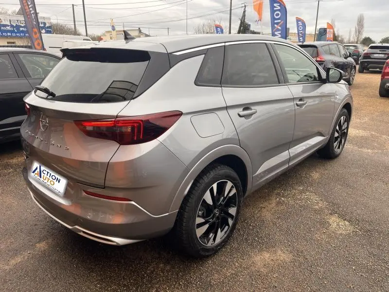 Vue 3/4 arrière droite d'un Opel Grandland gris Kontrast métallisé avec jantes alliage bi-ton et vitres teintées.
