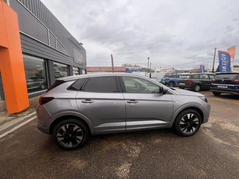 Vue de profil côté gauche d'un Opel Grandland gris Kontrast métallisé avec jantes alliage bi-ton 18 pouces.