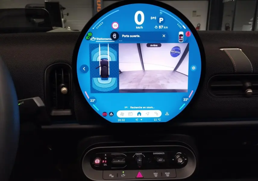 Vue intérieure centrée sur l'écran tactile rond affichant la caméra de recul, tableau de bord noir du MINI Cabriolet 2025.