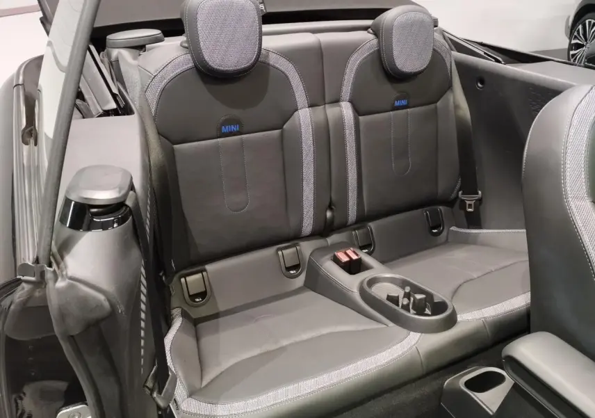 Vue intérieure arrière du cabriolet MINI noir, sièges arrière en similicuir perforé avec logo MINI bleu.