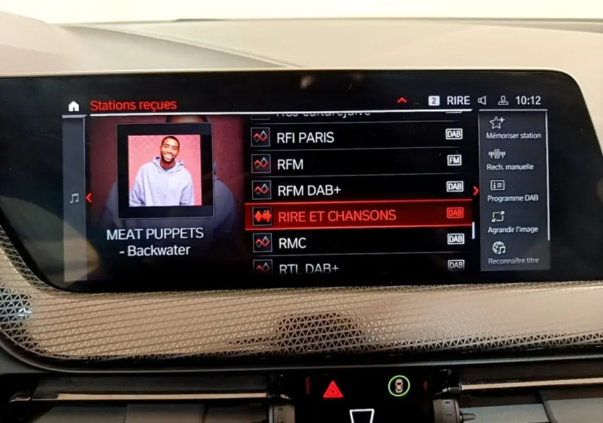 Écran tactile central de 10,25 pouces affichant les stations radio dans une BMW Série 1 118i Edition Sport 2023.