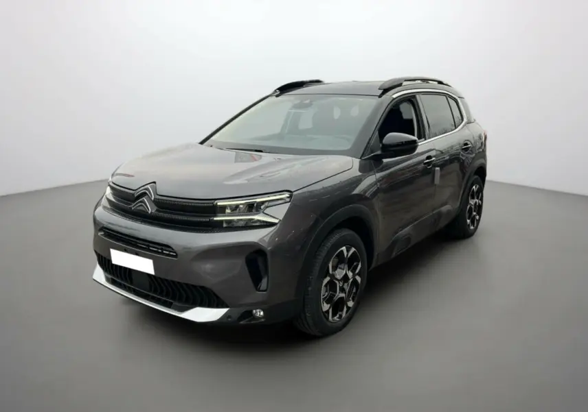Citroën C5 Aircross Hybrid 145 2025 gris platinium avec toit noir, vue 3/4 avant côté droit mettant en valeur ses jantes distinctives.