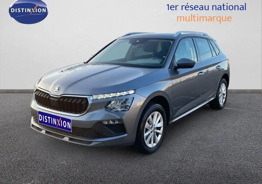 Vue 3/4 avant droite d'un Skoda Kamiq gris graphite métallisé 2024 avec calandre noire et jantes argentées.