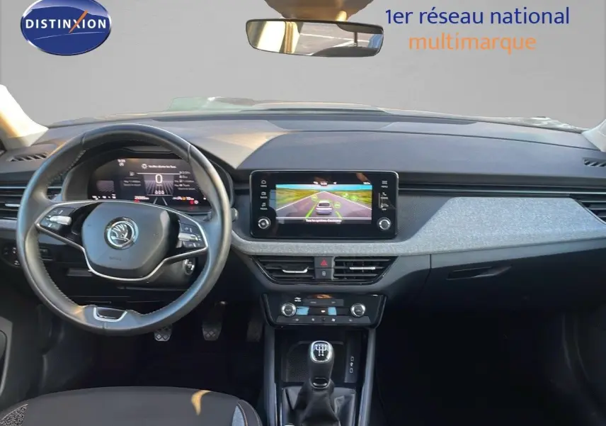 Vue intérieure avant du Skoda Kamiq 2024 gris graphite, avec tableau de bord numérique et écran tactile central.