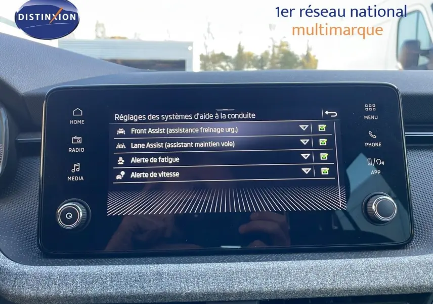 Écran tactile central du Skoda Kamiq 2024 affichant les réglages d'aides à la conduite avec interface moderne.
