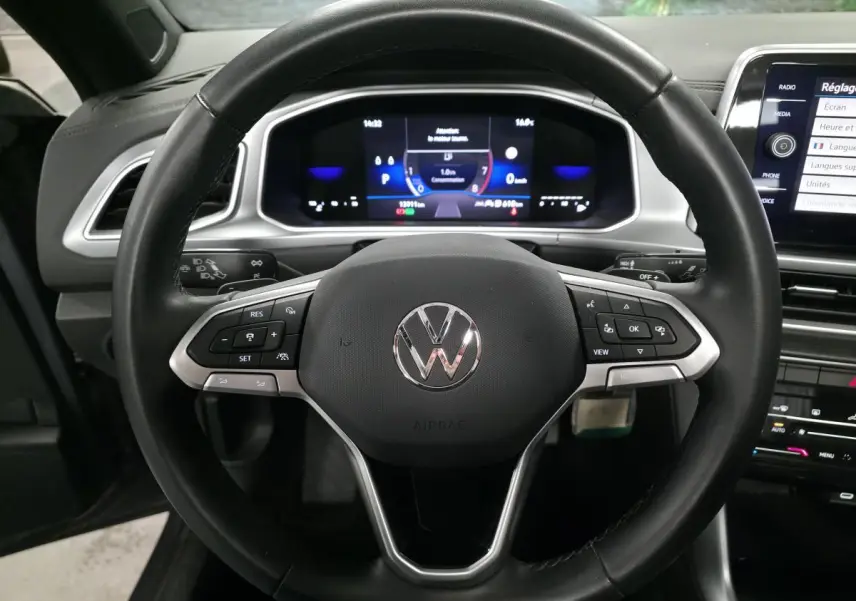 Vue frontale du volant en cuir noir multifonction du Volkswagen T-Roc 2024 avec tableau de bord numérique éclairé.