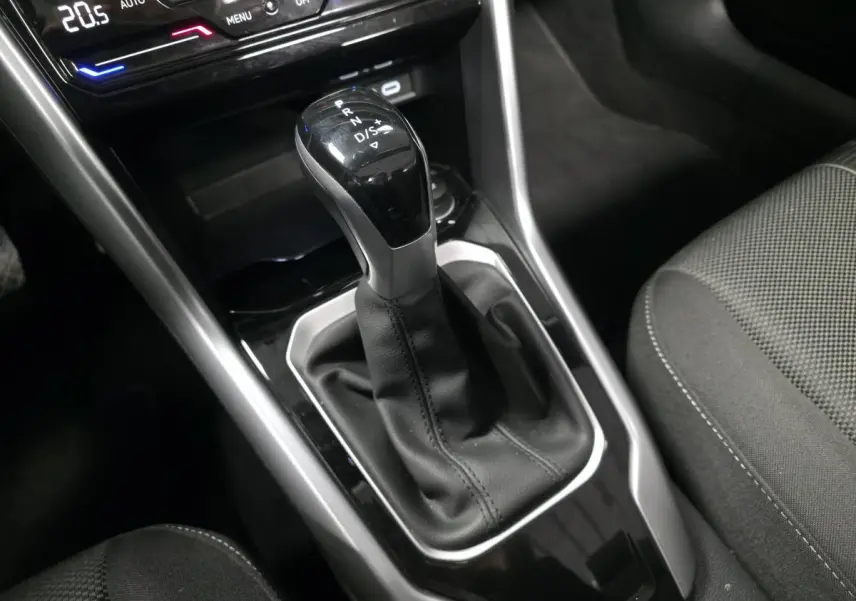 Le levier de vitesse automatique noir et argenté du Volkswagen T-Roc 2024, avec console centrale et sièges tissu gris.