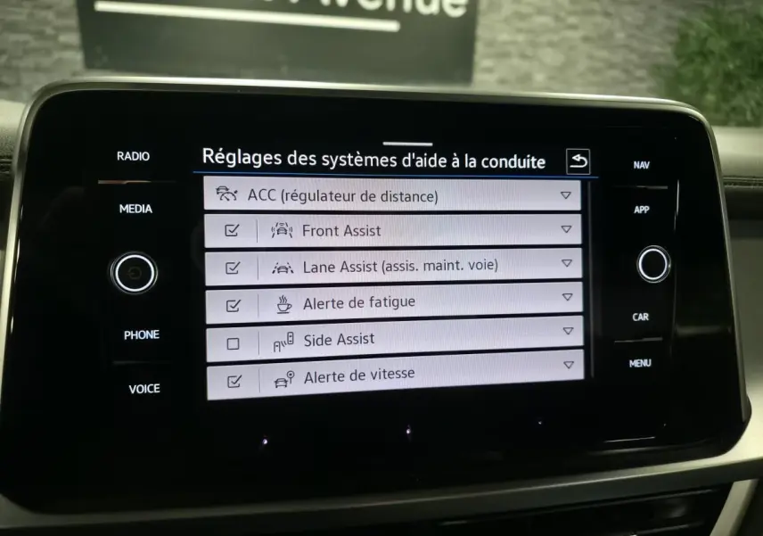 Écran tactile intérieur du Volkswagen T-Roc 2024 affichant les réglages des aides à la conduite.