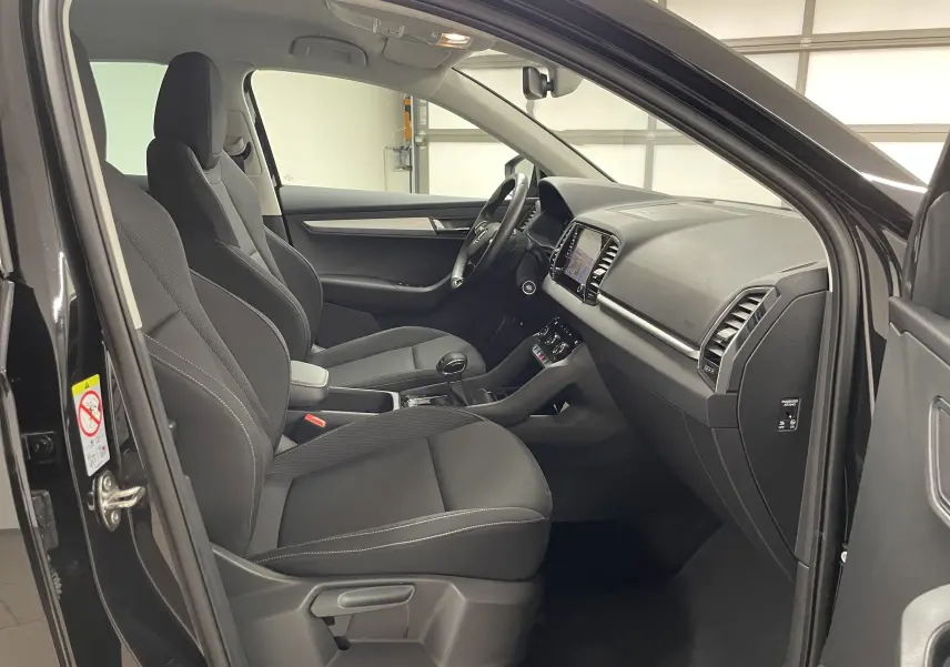 Intérieur côté conducteur du Skoda Karoq noir Magic nacré 2023, avec tableau de bord digital et sellerie noire.