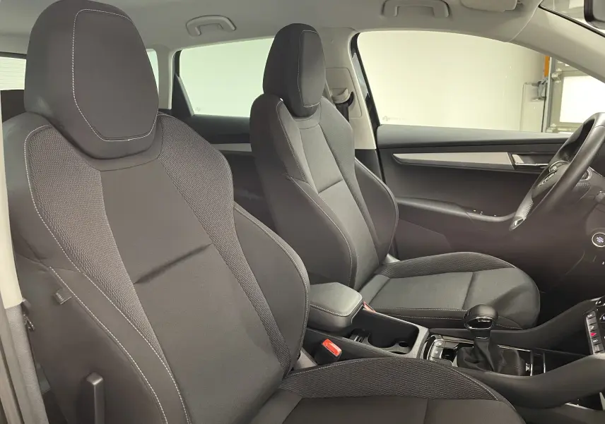 Vue intérieure côté droit du Skoda Karoq 2023, sièges tissu noirs avec coutures claires et console centrale visible.