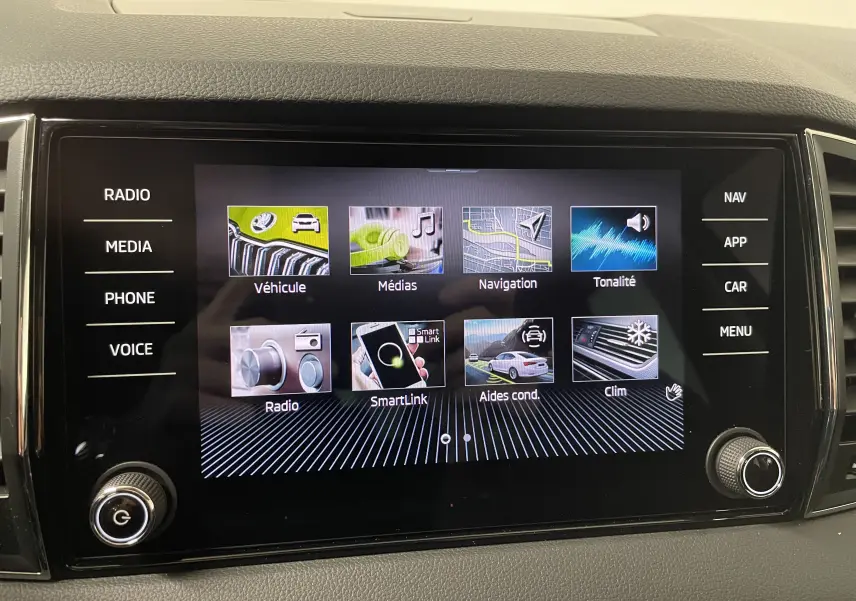 Écran tactile central du Skoda Karoq 2023 affichant les menus multimédias et aides à la conduite.