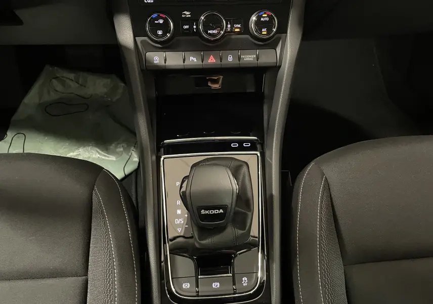 Vue rapprochée de la console centrale du Skoda Karoq 2023 avec levier de vitesses automatique et commandes climatisation.