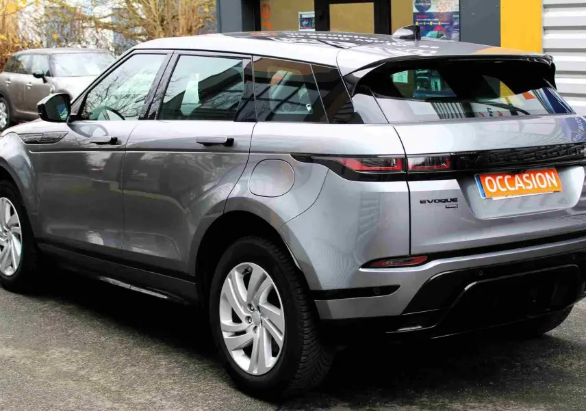 Vue 3/4 arrière droite d'un Range Rover Evoque gris métal 2023 hybride rechargeable avec plaque "OCCASION".