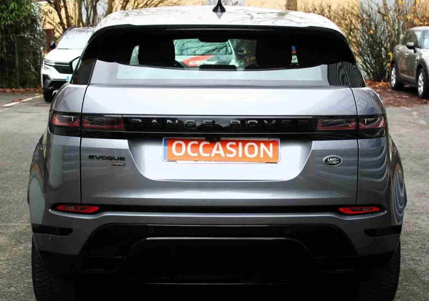 Vue arrière d'un Range Rover Evoque gris métal 2023 avec logo Land Rover et plaque "OCCASION" visible.