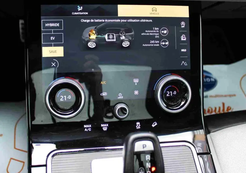 Gros plan sur la console centrale du Range Rover Evoque gris métal 2023, affichant l’écran tactile et le levier de vitesses.