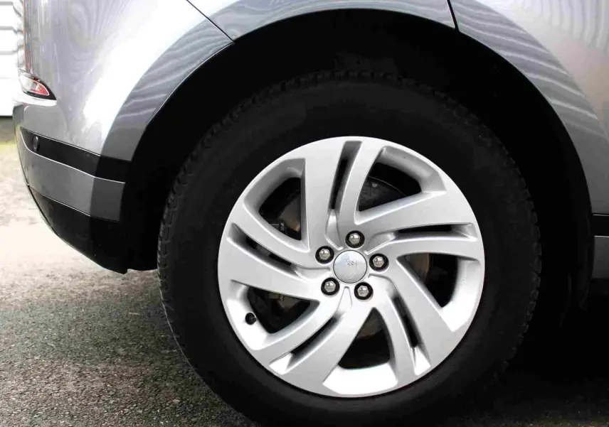 Gros plan sur la roue arrière droite du Range Rover Evoque gris métal 2023, mettant en valeur la jante alliage design.