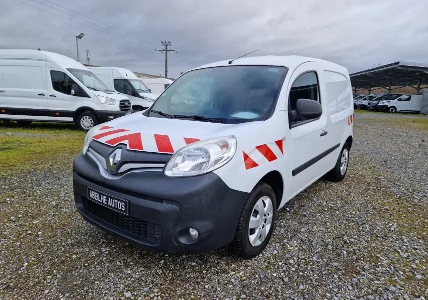 Renault Kangoo blanc vue 3/4 avant droit avec bandes rouges réfléchissantes sur capot et ailes.