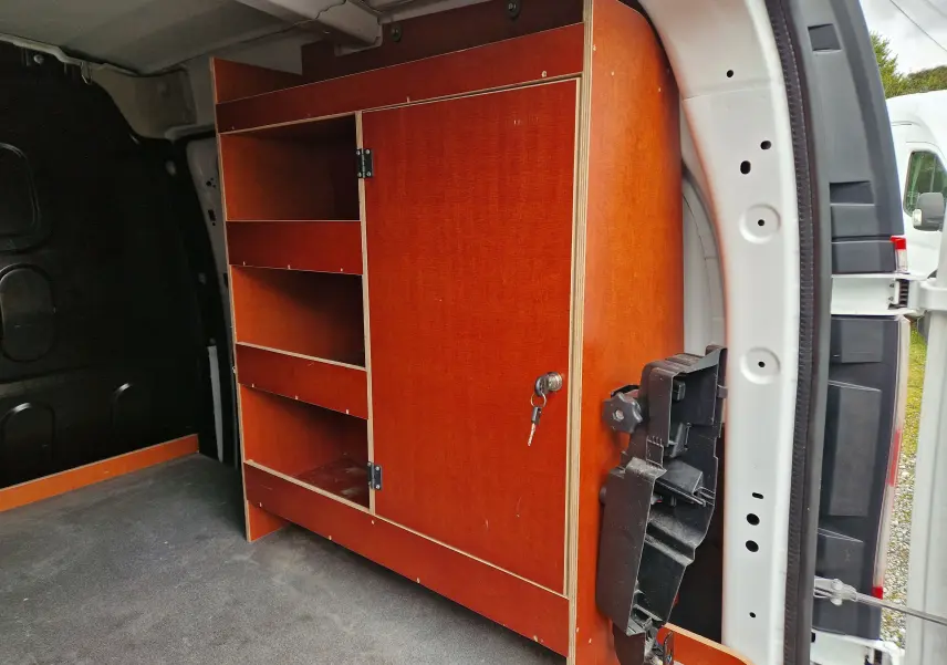 Vue intérieure côté droit du Renault Kangoo blanc 2019, montrant des étagères en bois intégrées dans le coffre.