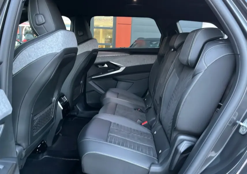 Vue latérale droite de l’intérieur arrière du Peugeot 5008 Hybrid 145 GT avec sièges en cuir Alcantara noirs et surpiqûres blanches.