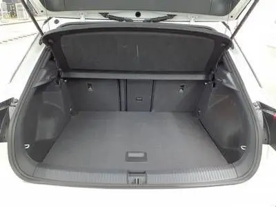 Coffre ouvert en vue arrière du Volkswagen T-Roc blanc pure toit noir, montrant un espace de chargement spacieux et propre.