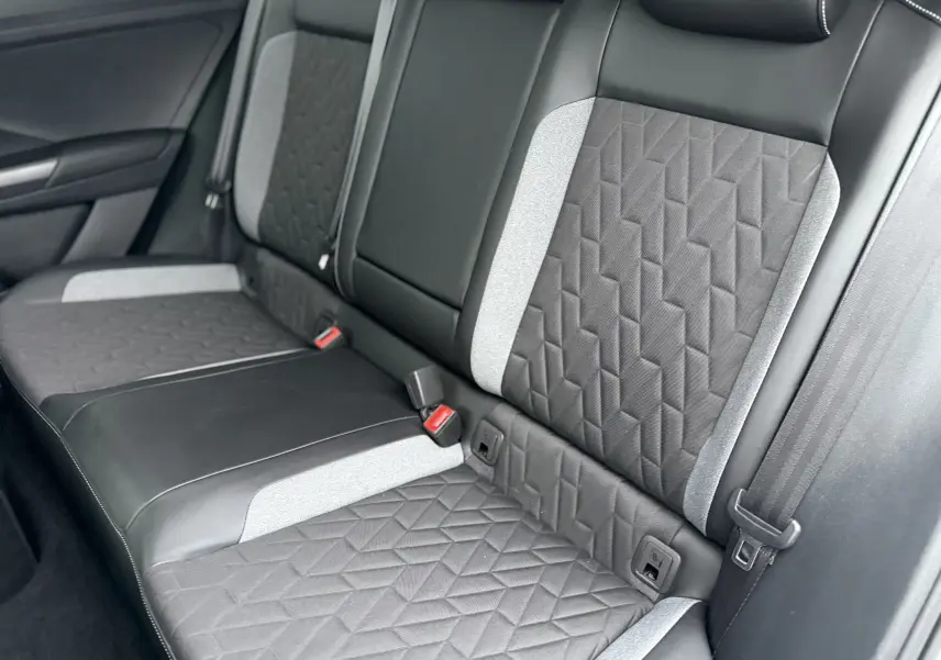 Vue rapprochée des sièges arrière du Volkswagen T-Roc 2025, tissu noir et gris avec motifs géométriques.