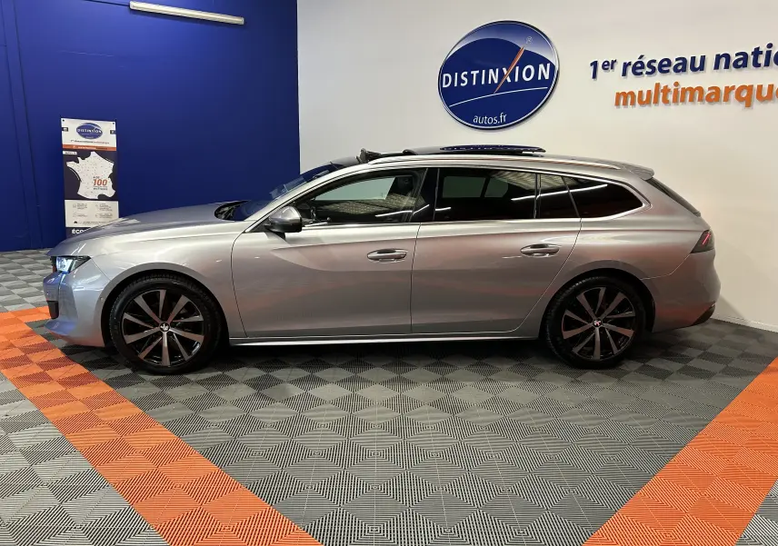 Peugeot 508 SW gris Platinium vue de profil côté gauche, avec toit ouvrant et jantes noires distinctives.