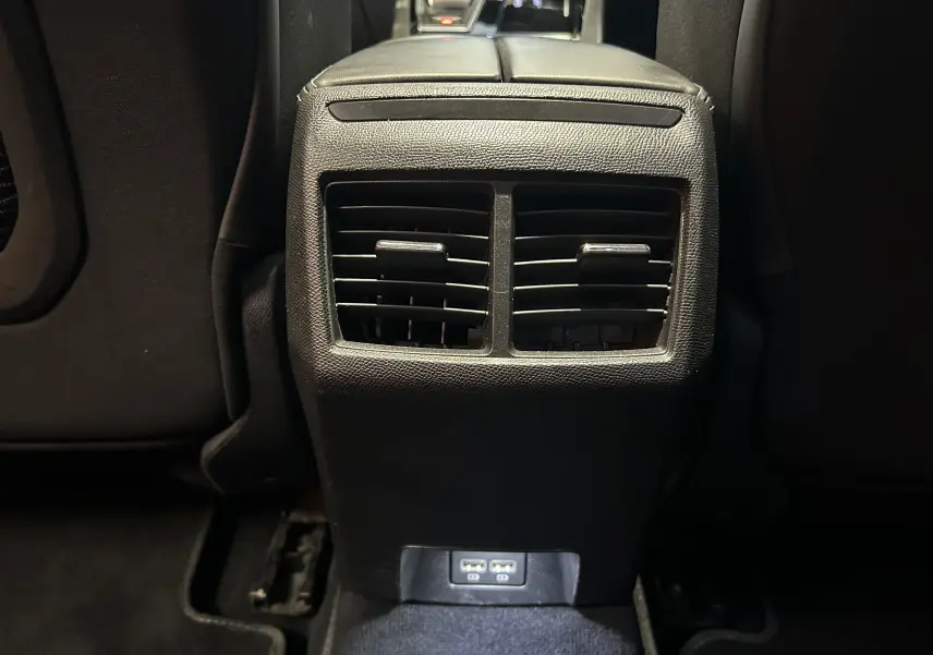 Vue rapprochée des aérateurs arrière et ports USB du Peugeot 508 SW gris Platinium, intérieur noir.