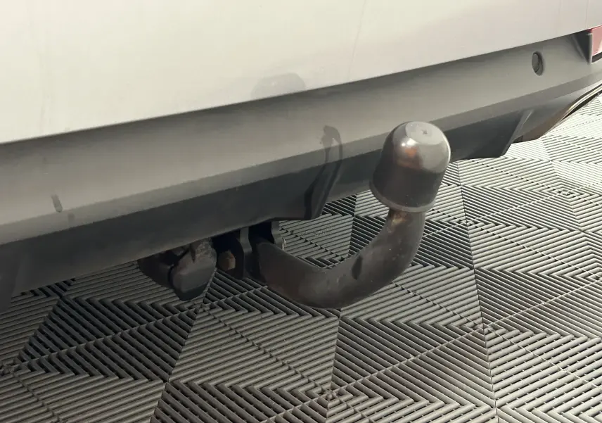 Gros plan sur l'attelage arrière d'une Peugeot 508 SW gris Platinium, avec protection en caoutchouc sur la boule.