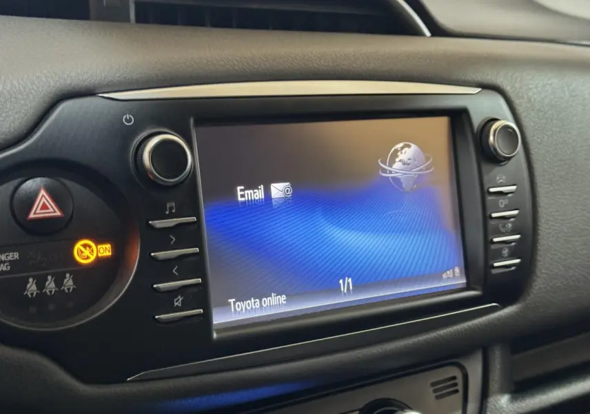 Écran tactile central allumé montrant l'interface Toyota online, entouré de boutons de commande noirs.