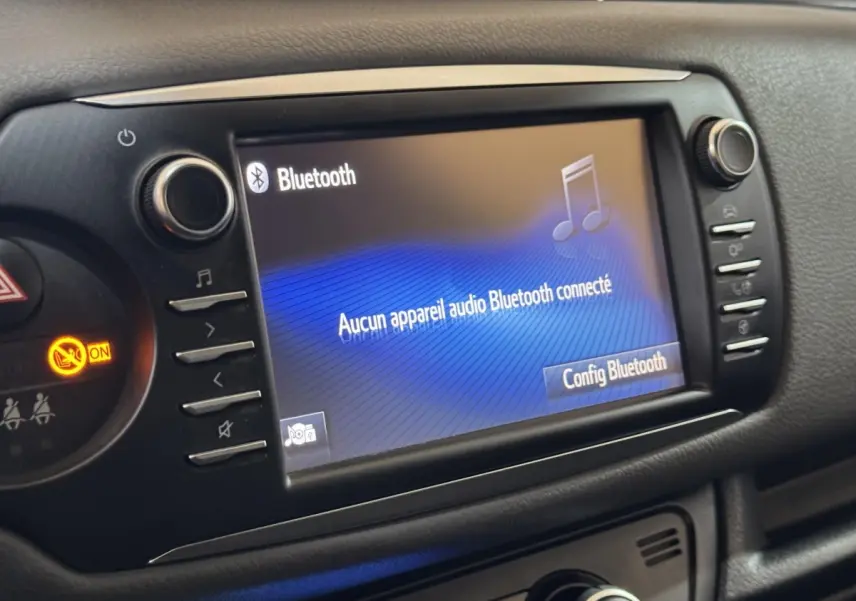 Écran tactile central affichant la connexion Bluetooth dans l’habitacle noir d’une Toyota Yaris hybride 2019.