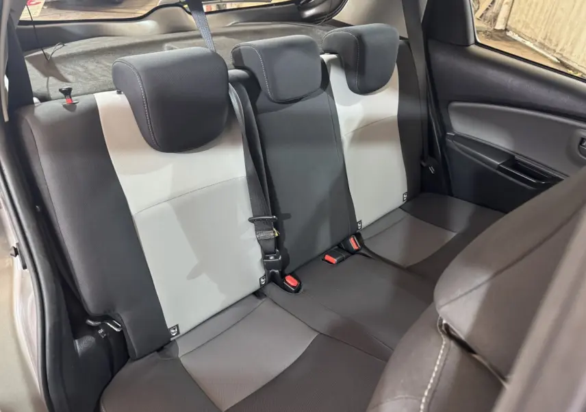 Vue intérieure de la banquette arrière bicolore gris clair et foncé de la Toyota Yaris 2019, avec appuie-têtes et ceinture de sécurité.