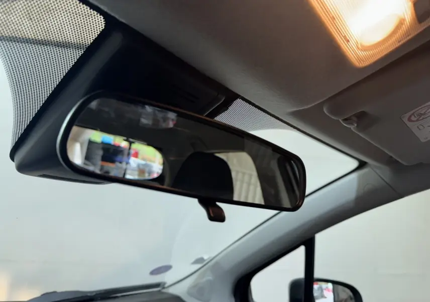 Vue intérieure du rétroviseur central d'une Toyota Yaris 1.5 VVT-I Hybrid 2019, avec plafond clair et lumière allumée.