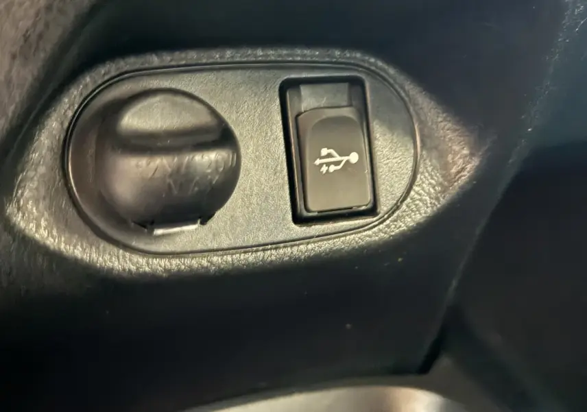 Détail intérieur du bouton d'ouverture du capot sur une Toyota Yaris 1.5 VVT-I Hybrid 2019, plastique noir.
