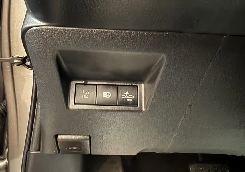 Gros plan sur les commandes de sécurité côté gauche du tableau de bord d'une Toyota Yaris gris foncé 2019.