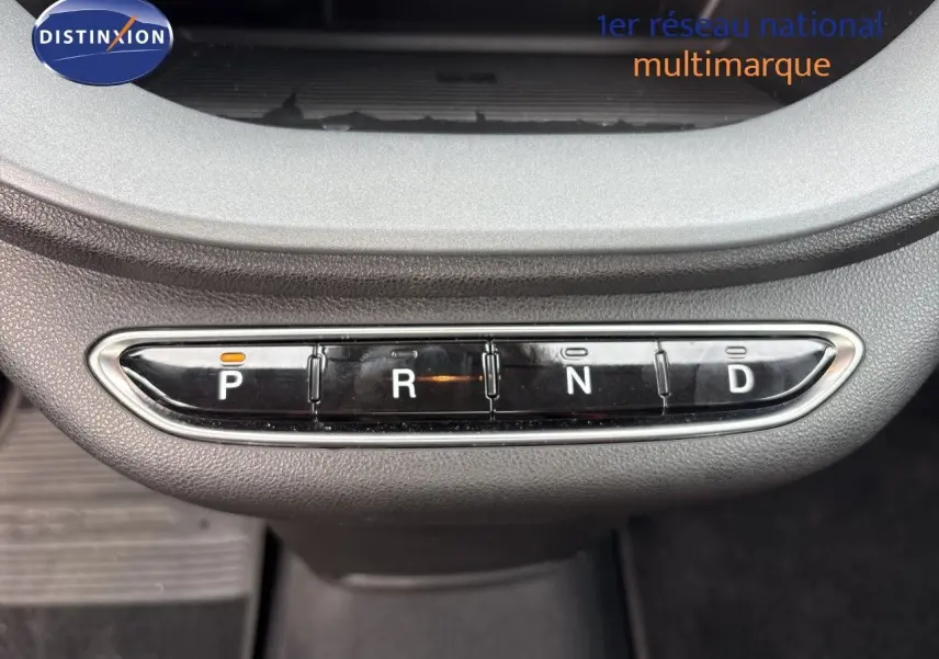 Gros plan sur la console centrale de la FIAT 500e rouge 2024 montrant les boutons de la boîte automatique P, R, N, D.
