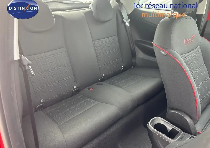 Vue intérieure montrant la banquette arrière et le siège avant droit noir avec surpiqûres rouges dans une FIAT 500e rouge.