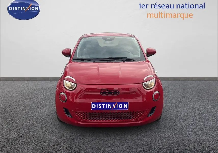 Vue frontale d'une FIAT 500e rouge électrique 2024 avec logo 500 noir et phares ronds allumés.