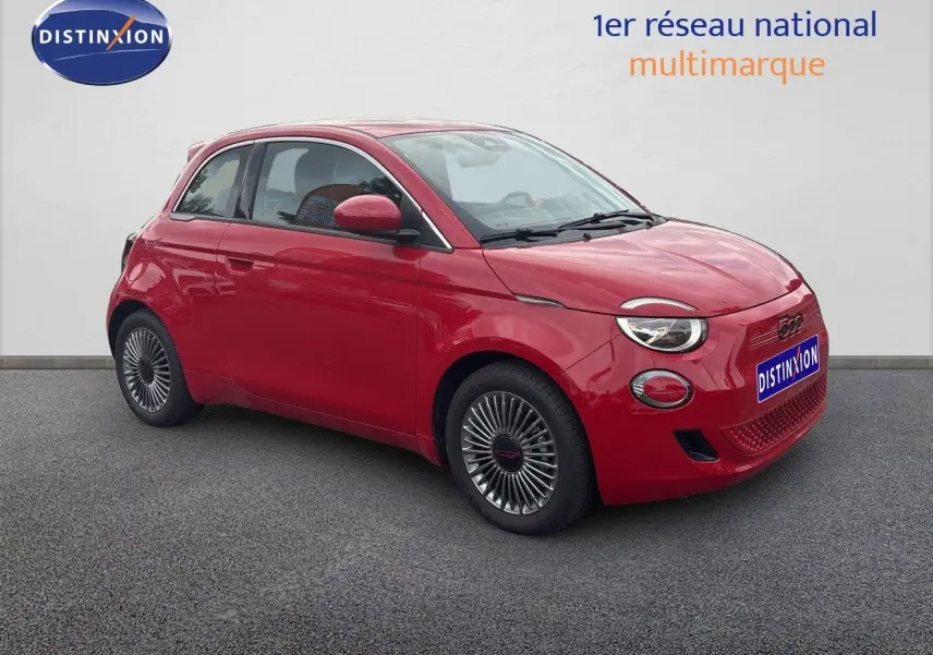 Fiat 500e rouge vue 3/4 avant droit, jantes classiques 15 pouces et phares ronds distinctifs.