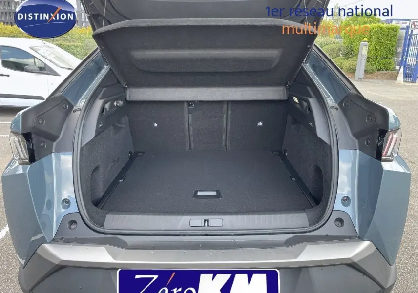 Coffre ouvert du Peugeot 3008 Hybrid 136ch Allure bleu Ingara Metal vu de l'arrière, montrant un espace de chargement spacieux.