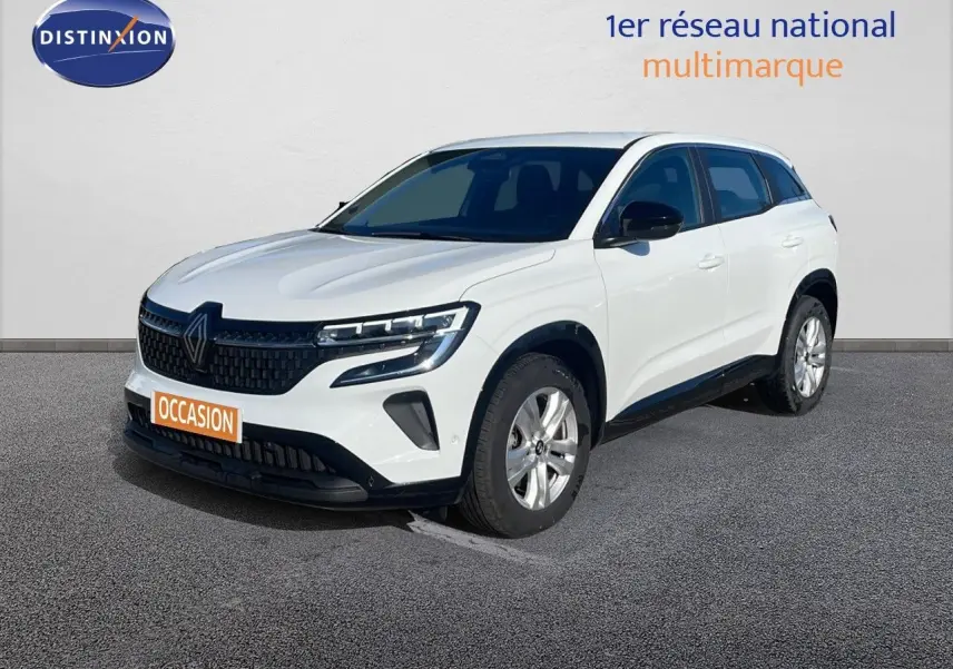 Renault Austral blanc glacier en 3/4 avant droit avec calandre noire et jantes alliage argentées visible sur sol gris.