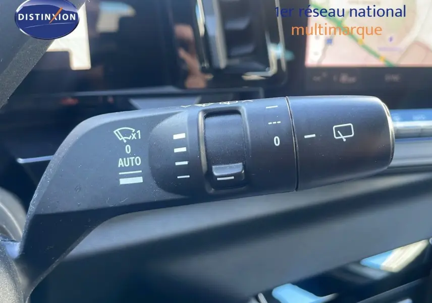 Gros plan sur la commande d'essuie-glace du Renault Austral 2023, intérieur avec écran tactile en arrière-plan.