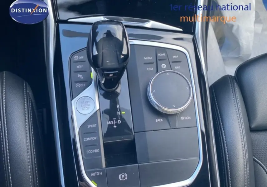 Gros plan sur la console centrale noire de la BMW Série 3 G20, avec levier de vitesses et commandes de mode de conduite.