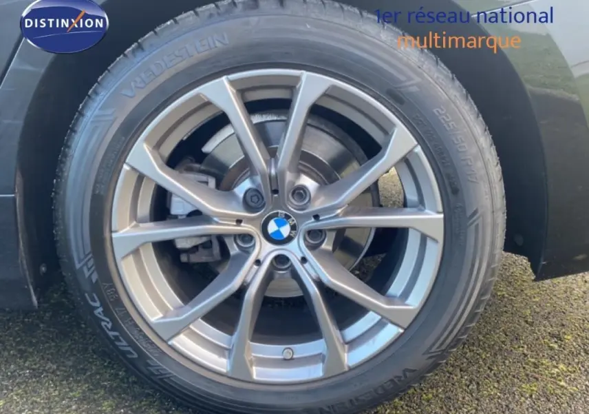 Gros plan sur la jante alliage 17 pouces argentée d’une BMW Série 3 noire, vue côté arrière droit.