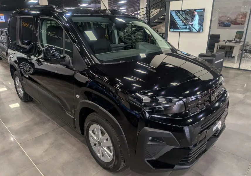 Peugeot Rifter Allure noir Perla Nera en 3/4 avant droit, avec calandre noire et jantes argentées en showroom.