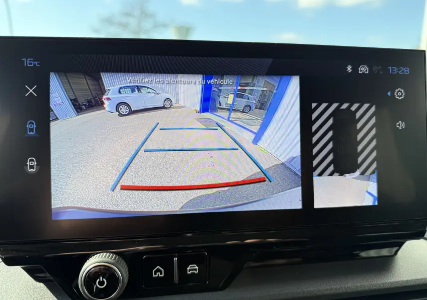 Écran de caméra de recul du Peugeot Rifter noir Perla Nera montrant l’arrière avec lignes de guidage et vue latérale droite.